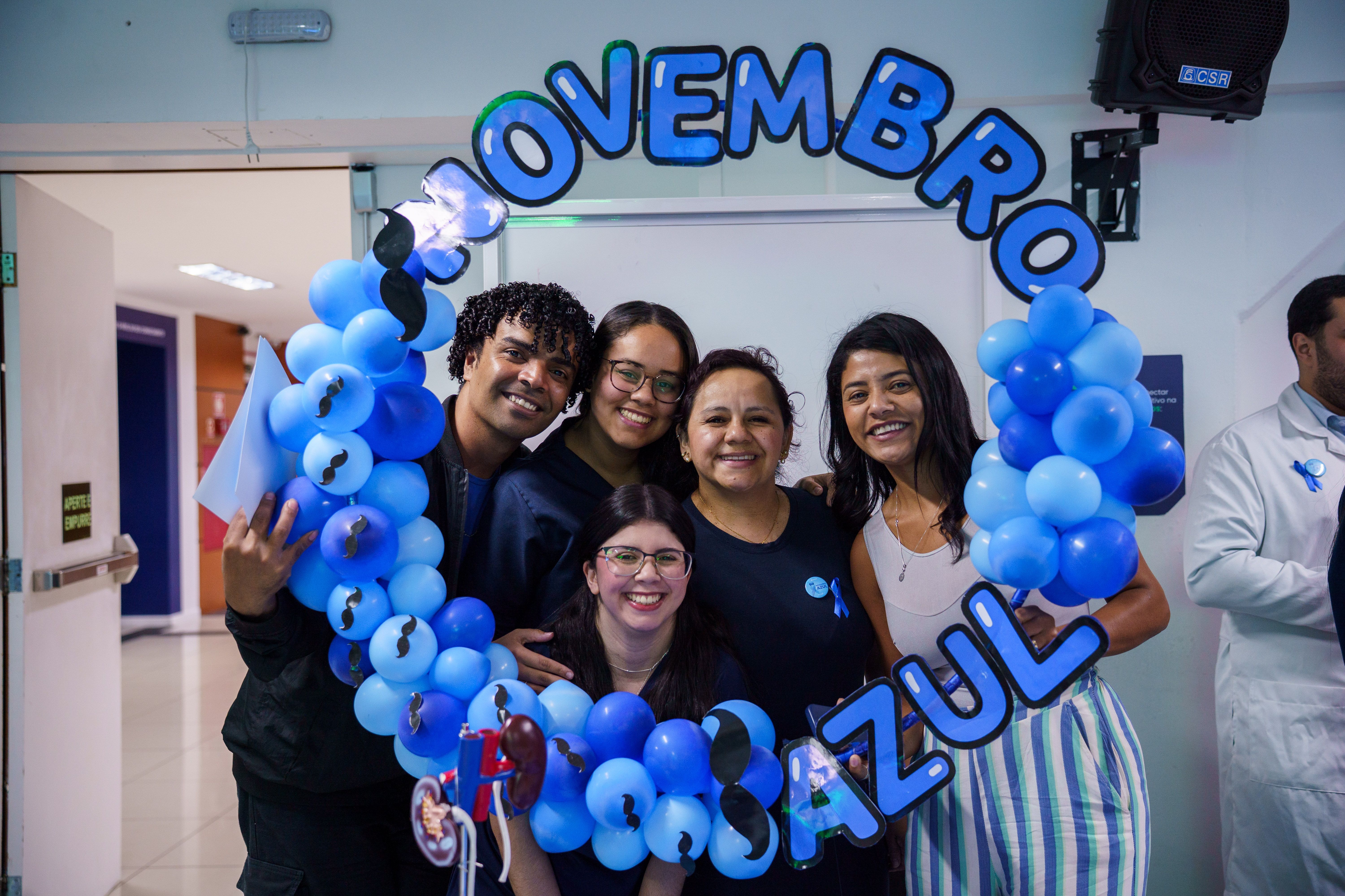 Estudantes olhando para foto sorrindo com uma faixa escrito novembro azul UniFECAF.jpg
