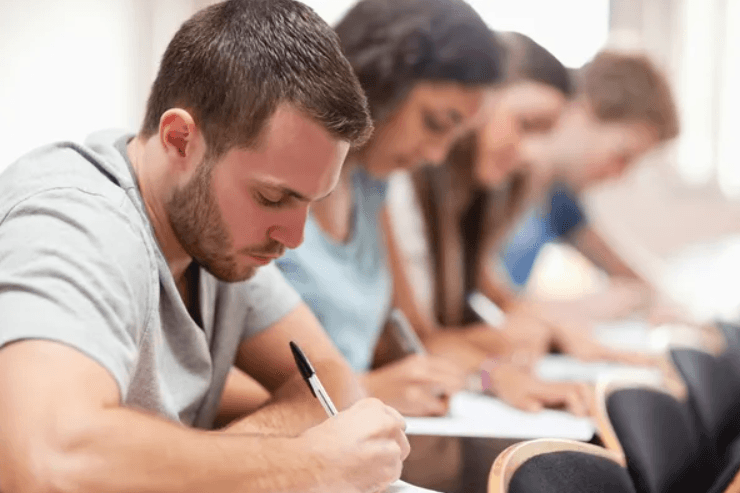 Estudantes escrevendo em sala de aula.