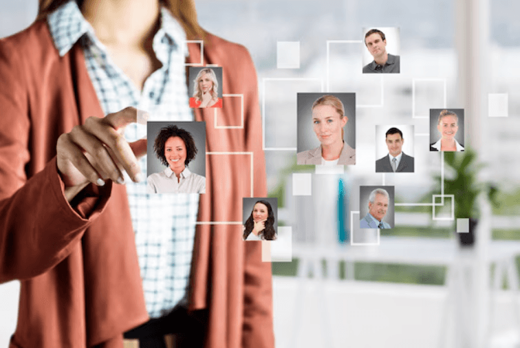 Mulher interagindo com tela virtual exibindo fotos de profissionais conectados.